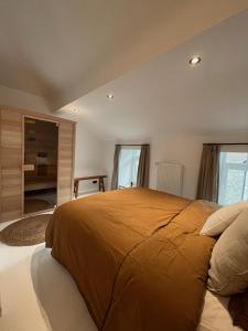 马尔什昂法梅讷L'Officine - Résidence Le Cercle的一间卧室配有一张带橙色毯子的大床