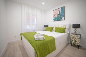 马德里Apartment IFEMA-Mar de Cristal II的白色卧室,配有一张带绿毯的床