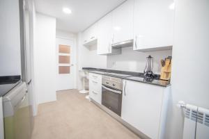 马德里Apartment IFEMA-Mar de Cristal II的厨房配有白色橱柜和炉灶。