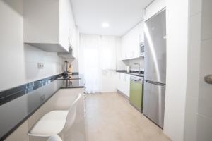 马德里Apartment IFEMA-Mar de Cristal II的白色的厨房配有白色的柜台和电器