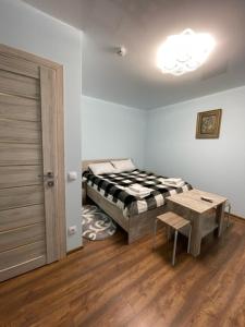SukhostavГотель ТІК Копичинці的一间设有床、桌子和门的房间