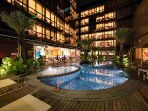 新加坡Ibis Styles Singapore On Macpherson的中间有一座大游泳池的建筑