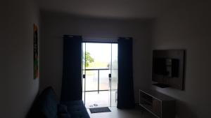 伊塔尼亚恩AbeQuar apartamentos beira-mar para temporada的客厅设有滑动玻璃门和电视