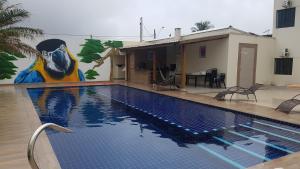 伊塔尼亚恩AbeQuar apartamentos beira-mar para temporada的一座带壁画的游泳池,位于房子旁边