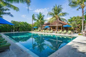 沙努尔Sudamala Resort, Sanur, Bali的棕榈树度假村的游泳池