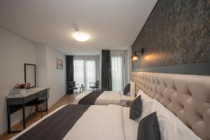 伊斯坦布尔KA Hotel & Suites的酒店客房配有两张床和一张书桌