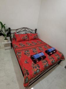 斯里伊斯兰德LYNN HOMESTAY SERI ISKANDAR的一张带红色棉被的床和两个枕头