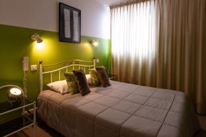 卢布雷萨克Hôtel le Cantou 354的一间卧室设有一张带绿色墙壁和窗户的床。