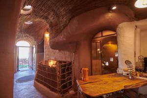 圣佩德罗·德·阿塔卡马CASA PEQUÉN的带桌子的客房内设有带石制壁炉的厨房