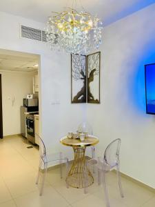 拉斯阿尔卡麦Luxurious Studio Pacific Al Marjan Island - beachfront property的一间带桌椅和吊灯的用餐室