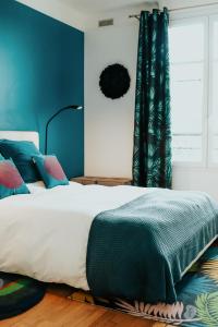 凡尔赛SweetHomeVersailles brand new flat 5mn walk from the Palace的一间卧室配有一张蓝色墙壁的床和一扇窗户