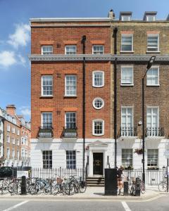 伦敦Luxury 1-bedroom apartment in Marylebone的一座大型砖砌建筑,前面停放着自行车
