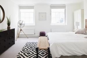 伦敦Luxury 1-bedroom apartment in Marylebone的白色卧室配有床和风扇