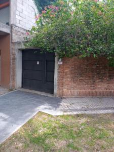 罗萨里奥Jardin Secreto的一个带黑色门和砖墙的车库