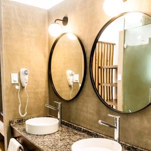 米娜克拉韦罗Favre Suites的一间带两个盥洗盆和大镜子的浴室