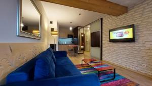 考斯赛力克Apartament Widokowy 40的客厅设有蓝色的沙发和砖墙上的电视