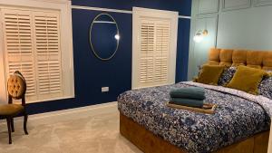 伦敦德里ENAS COVE Homely Getaway的一间卧室配有一张带镜子和椅子的床
