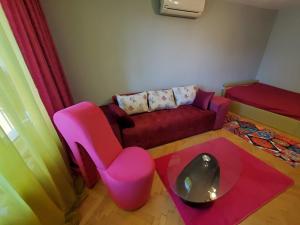 普罗夫迪夫Свежест и Уют Център Безплатен Паркинг Релакс的客厅配有沙发和粉红色椅子