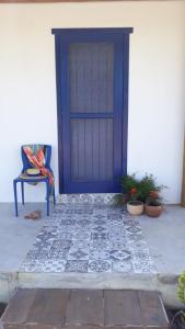 哥隆巴奥Aldeia Corumbau的白色建筑中一扇蓝色门,上面有盆栽植物