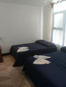 奎波斯城Pura vida apartments的客房内的两张床和白色毛巾