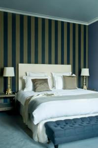 尼奥尔巴尔迪库里尔酒店的一张白色的大床,在房间里设有蓝色长凳