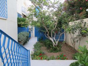 纳布勒Villa Kenza的建筑物前的蓝色栅栏和一棵树