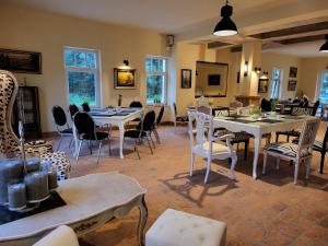 米罗Hotel & Ferienpark Fleether Mühle的用餐室设有桌椅和窗户。
