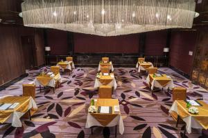 达卡InterContinental Dhaka, an IHG Hotel的一间带桌子和大吊灯的用餐室