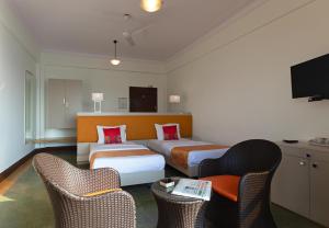 孟买大海绿色酒店 的酒店客房,配有两张床和两把椅子