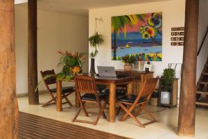 伊塔卡雷Mar Ilha Pousada的用餐室配有桌椅和笔记本电脑