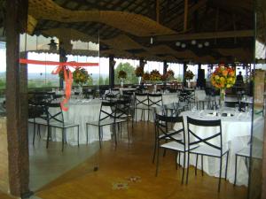 蒂拉登特斯Pousada Serra Azul的配有桌椅和白色桌布的房间