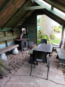 利克Leek Camping Barns的庭院配有桌椅和炉灶。