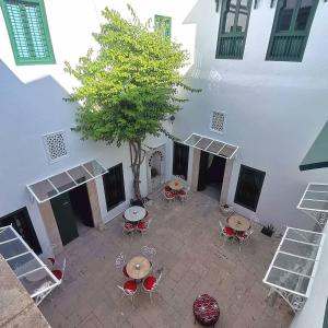 突尼斯Dar el médina的享有庭院的顶部景色,设有桌子和一棵树