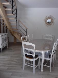 TirepiedGite Le Ranch 6 pers的一间带桌椅和楼梯的用餐室