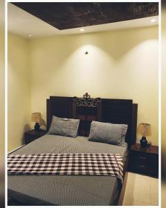 AusiaFull Serviced Cottage in Bhurban的一间卧室配有一张带 ⁇ 子毯子的床