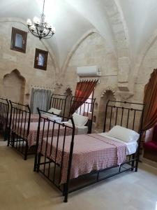 马尔丁Mardin tarihi ulu Cami yanı, tarihi Konak的一间卧室配有三张床和吊灯。