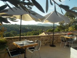 圣保罗－勒热讷马斯蒙蒂德斯酒店的庭院里配有两张桌子和椅子以及遮阳伞
