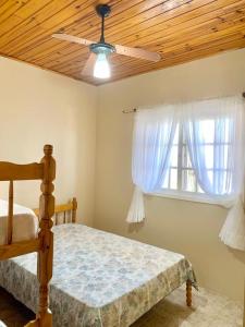 因贝Apartamentos Vitali的一间卧室配有一张带吊扇和窗户的床。