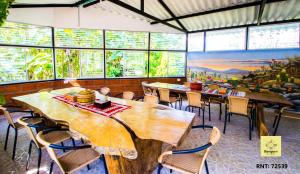 马尼萨莱斯Bosques de la Pradera的餐厅设有木桌、椅子和窗户。