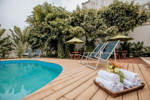 卡塔赫纳卡萨布斯塔曼特精品酒店的一个带椅子的甲板和一个游泳池
