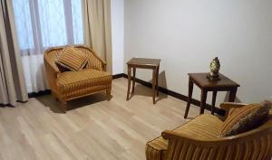 昆卡Hotel El Conquistador的客厅配有两把椅子和一张桌子