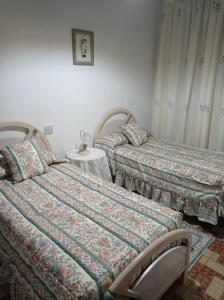 塞埃欣Casa rural "La Bodega"的一间卧室配有两张床和一张桌子及床头柜