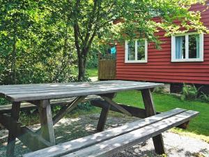 Henån5 person holiday home in HEN N的红色房子前的木餐桌