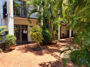 达尔文椰林假日公寓 的一座楼前种有棕榈树的庭院