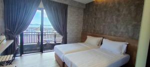 仙本那Cube Bed Station & Tours Sdn Bhd的一间卧室设有一张床和一个阳台的窗户。