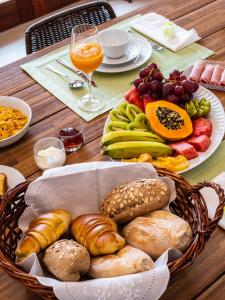 明德卢Casa da Djedja的一张桌子,上面放着一篮子不同种类的面包和水果