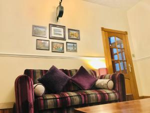 MarkinchStation View Lodge Markinch的客厅配有带紫色枕头的沙发
