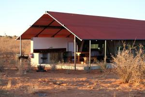 马林塔尔Kalahari Anib Camping2Go的沙漠中一座有红色屋顶的建筑