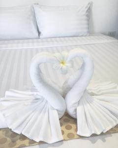 湄南海滩The Cosy Maenam Beach Resort的两个天鹅在床上形成心