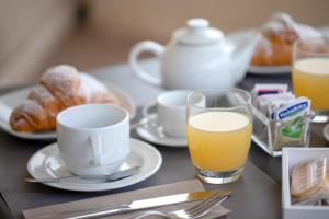 法维尼亚纳尹苏拉酒店的一张桌子,上面放着一杯橙汁、咖啡和羊角面包